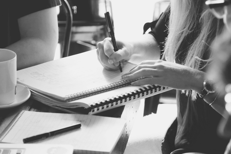 Une femme qui prend des notes sur un cahier